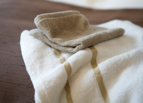 Witte handdoek met beige strepen en een washandje